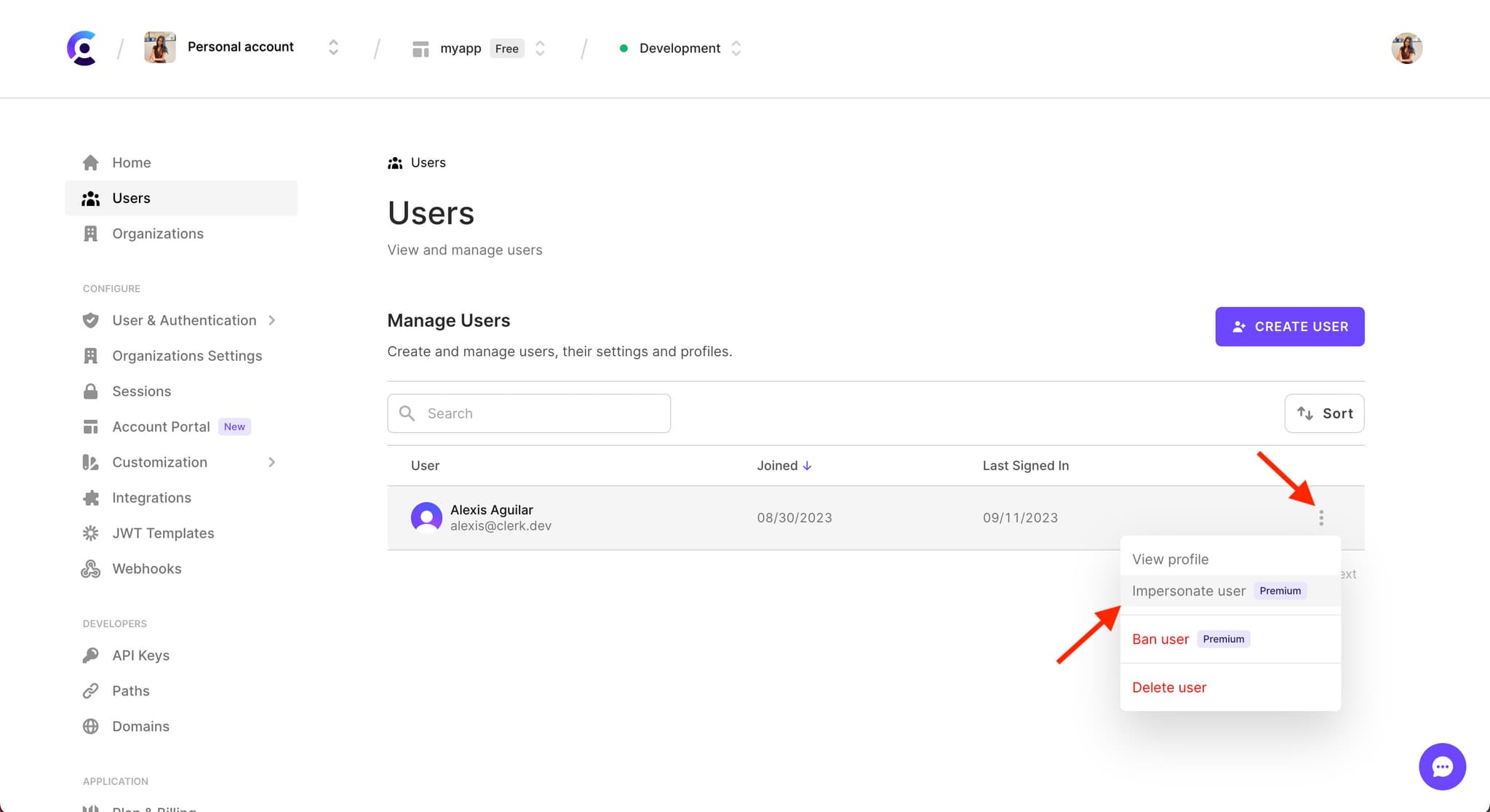 The 'Users' page in the Clerk Dashboard. A red arrow points to the 3 dots menu icon on the right side of a user's row. A dropdown menu is shown a red arrow pointing to the hovered-over 'Impersonate user' option.